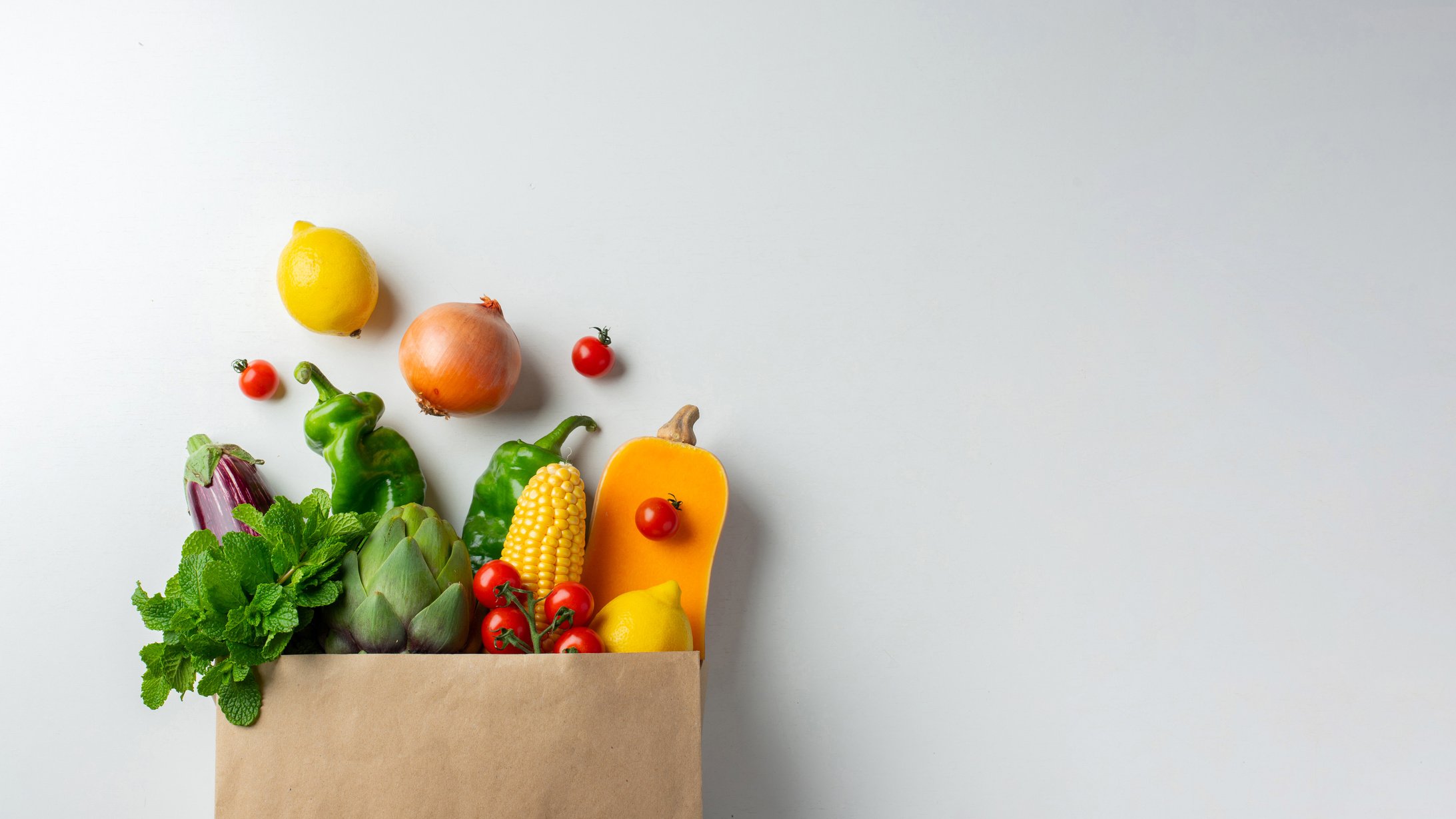 Delivery healthy food background. Healthy vegan vegetarian food in paper bag vegetables and fruits on white, copy space, banner. Shopping food supermarket and clean vegan eating concept